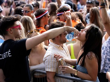 security pours water into the mouth of a fan at osheaga