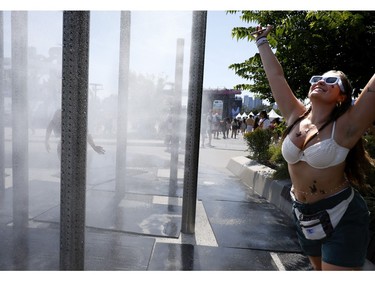 Olivia from Boston takes in the misting station at Osheaga in Montreal on Sunday, Aug. 6, 2023.