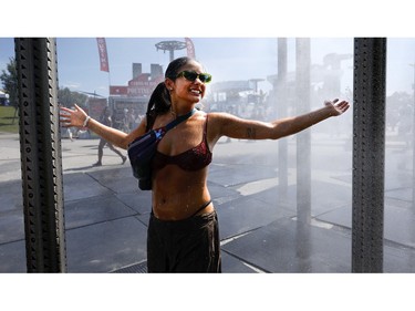 Sasha cools off in the misting station at Osheaga in Montreal on Sunday, Aug. 6, 2023.