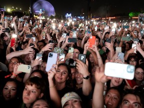 a crowd holding up phones to kendrick lamar at osheaga