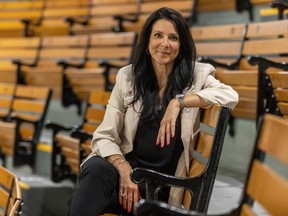 Annie Larouche sits on a wooden bench in the stands