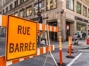 A sign on a barrier indicates that a street is closed due to construction