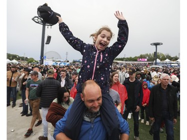 Gabriella Vriniotis sits on her father Dennis Vriniotis' shoulders at the Lasso country-music festival at Parc Jean-Drapeau in Montreal on Saturday, Aug. 19, 2023.