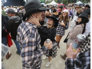 Maeka Huard looks to adjust her boyfriend Jayson Grenier's hat at the Lasso country-music festival at Parc Jean-Drapeau in Montreal on Saturday, Aug. 19, 2023.