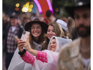 From the left: Valerie Laplante, Audrey Chevrette and Annedriane Bilodeau take a selfie at the Lasso country-music festival at Parc Jean-Drapeau in Montreal on Saturday, Aug. 19, 2023.
