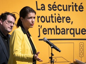 Quebec Transport Minister Geneviève Guilbault and Quebec Education Minister Bernard Drainville announce new road-safety measures in front of a sign that says i'm embarking on road safety