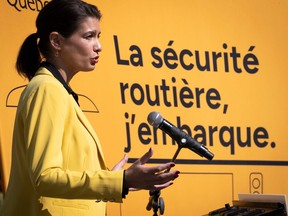Quebec Transport Minister Geneviève Guilbault dressed in yellow, standing at a podium with a darker yellow background