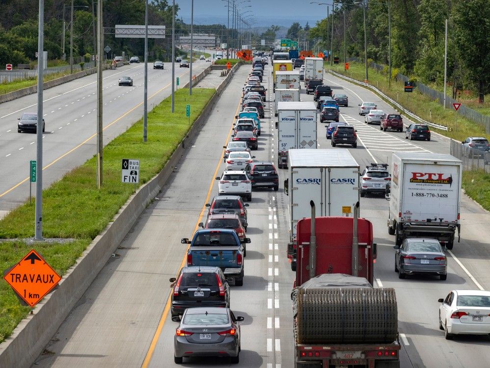 Traffic is scene on a highway with a construction sign