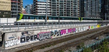 The new REM track, with train whizzing by condo towers, and already graffiti lines the route.