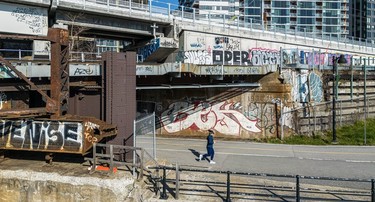 A jogger surrounded by graffiti on the Lachine Canal near the Peel Basin in Griffintown.