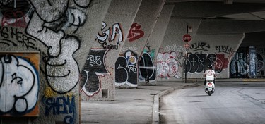 Graffiti adorns the grey concrete supports under the Rosemont Blvd. overpass.