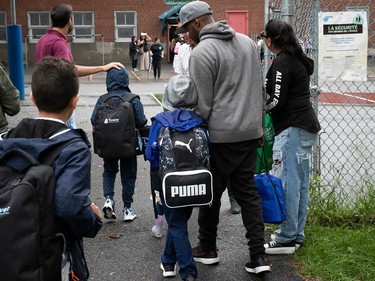 Parents and students arrive at a school yard