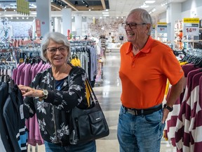 Joanne and Michel Côté among clothing racks