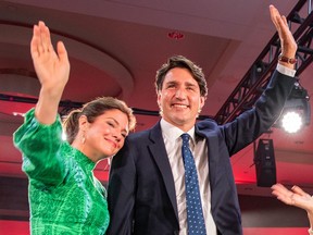 Justin Trudeau and Sophie Grégoire wave to supporters inside a large room