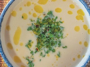Fennel kohlrabi soup in a blue and white bowl. It is garnished with gremolata