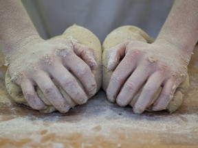 A break factory worker kneads dough.