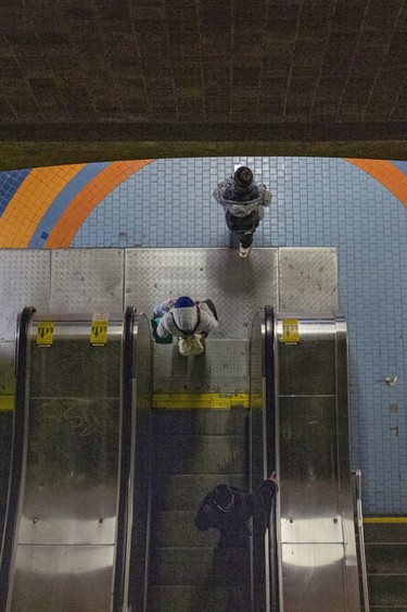 Transit users descend escalators at the Jean-Talon Metro station.