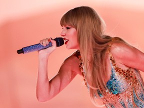 Taylor Swift leans forward while singing