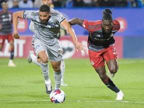 A CF Montréal and Toronto FC player race for a ball during a game