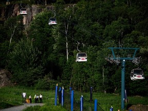 Cadets from the Surete du Quebec stand near the base of a chairlift where one person died and another was seriously injured after a gondola crashed into a piece of construction equipment at Mont-Tremblant Resort on Sunday, July 16, 2023.
