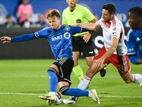 New England Revolution's Matthew Polster, right, challenges CF Montréal's Bryce Duke during first half MLS soccer action in Montreal on Saturday, Aug. 26, 2023.