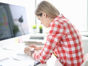 A woman slouches at a computer desk