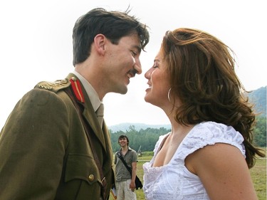 Justin Trudeau, wearing a First World War military uniform and sporting a moustache, leans in to kiss Sophie Grégoire Trudeau, wearing a white summer dress, on a field