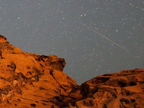 meteor showers and a starry sky over red cliffs