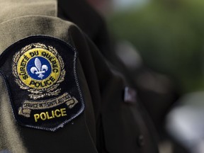 A police emblem is seen on a sleeve.