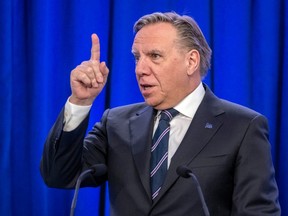 Quebec Premier François Legault holds up his index finger during a press conference in Montreal on March 24, 2023.