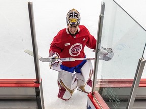 Jacob Fowler smiles as he looks up at the camera in front of an open door at the side of a rink