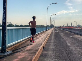 A man jogs across a bridge. The geodesic dome is in the background