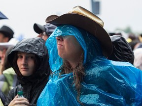 A person in a cowboy hat and a plastic poncho in a crowd