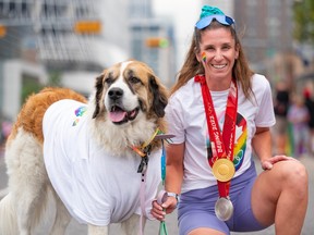 Team Canada speedskater Ivanie Blondin poses for a photo with her dog Brooke while wearing her Olympic medals at the Calgary Pride Parade.