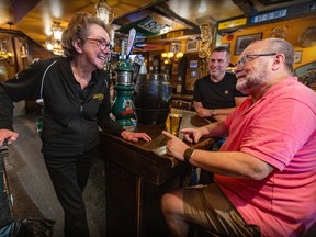 Teresa Slevin speaks to two men over the corner of the bar at McKibbins