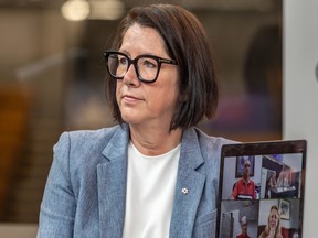 Danièle Sauvageau with a computer screen showing people attending a news conference via video conference