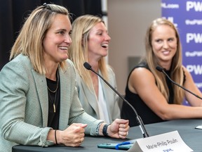 Marie-Philip Poulin, left, Laura Stacey and Ann-Renée Desbiens at a table during a news conference