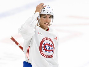 Logan Mailloux, clad in the Canadiens' practice white jersey, puts his hand on his helmet and takes a breather during rookie camp on Thursday.
