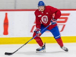 Canadiens prospect David REinbacher, wearing a red jersey and blue hockey pants, skates with the puck at rookie camp in Brossard.