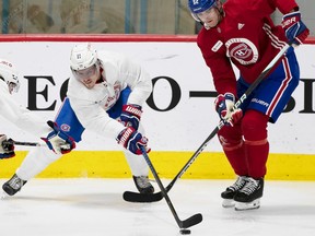 Canadiens' Brendan Gallagher, left, in a white jersey, and Justin Barron, in red, battle for the puck during Habs training camp in Brossard last week.