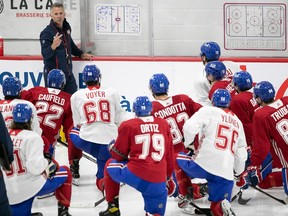 Canadiens head coach Martin St-Louis draws on a white board as attentive players kneel on the ice before him during training camp in Brossard on Thursday.