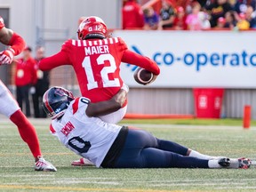 Alouettes' Shawn Lemon is seen on the ground dragging down Stampeders quarterback Jake Maier for a sack last week.