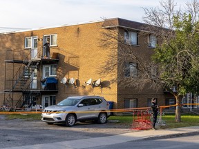 Police officers secure an apartment building where the bodies of two women were found in Longueuil on Wednesday, Sept.27, 2023.