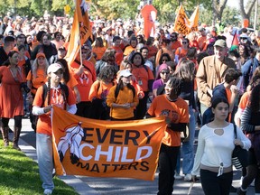 Marchers carry orange banners on Parc Ave in Montreal as part of National Day of Truth and Reconciliation in 2022.