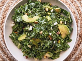 Kale and avocado in a white bowl on a rattan placemat.