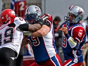 Alouettes tackle Josh Bourke, wearing Montreal’s blue, red and white uniforms, protects quarterback Anthony Calvillo during a game in 2009.