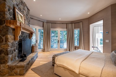 A bedroom at the Estrie property has its own fireplace.