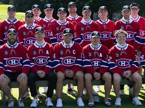 Canadiens players in team jerseys and shorts pose for a team photo on a golf course