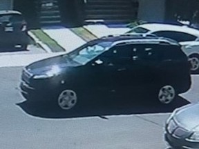 A black Jeep Cherokee is seen on a residential street in a surveillance video still