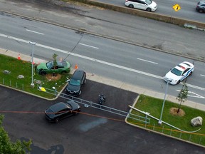 An aerial view of an accident. Four cars are in various positions around the frame with debris scattered around a green car to the left of the frame.